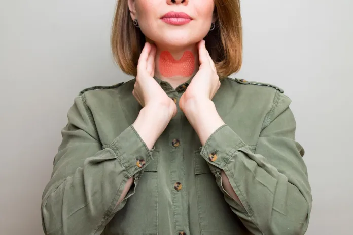 Kobieta dotyka szyi w badaniu fizykalnym nadczynności tarczycy